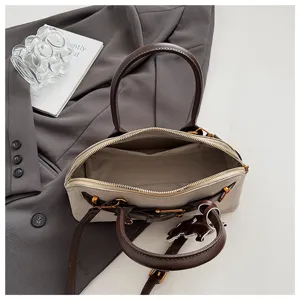 Schicke Handtasche aus Wildleder-Patchwork mit elegantem Gürtel und Pferde-Anhänger.