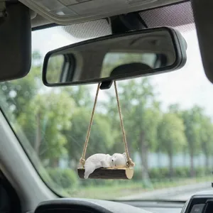 Gros plan détail du mignon ours polaire endormi en résine balançoire rétroviseur voiture.