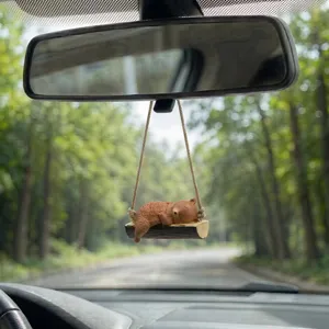 Gros plan détaillé du charmant pendentif de ours endormi sur balançoire pour rétroviseur auto.