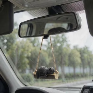 Vue détaillée du charmant pendentif de voiture en forme d'ours noir sur balançoire, rétro.