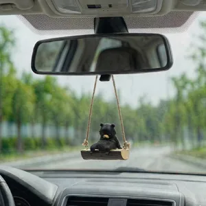 Vue détaillée de l'ornement suspendu de rétroviseur de voiture d'ours noir de balançoire.