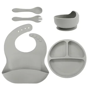 Grey silicone baby feeding set with divided plate, bowl, bib, spoon, and fork for infants.