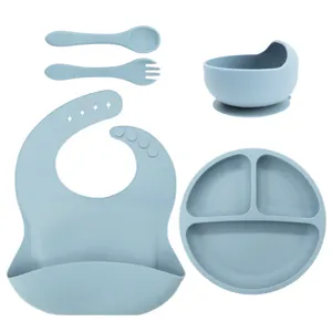Detailed view of silicone baby feeding set including divided suction plate, bowl, bib, spoon, fork.