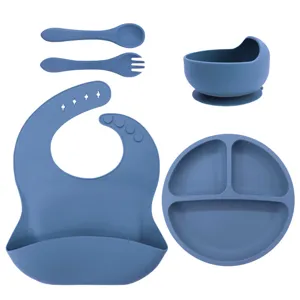 Silicone baby feeding set with divided suction plate, bowl, spoon, fork, and adjustable bib.