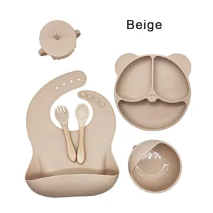 Siliconen baby voedingsset in beige met berenbord, kom, beker, slabbetje. Detailweergave.