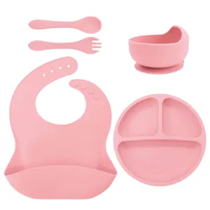 Silicone baby feeding set detail, pink suction bowl and divided plate close-up view.