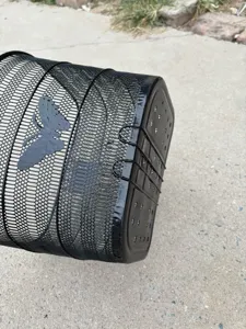 Vista dettagliata di un cestino per bici in metallo nero con ritaglio a farfalla decorativo.