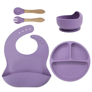 Silicone baby feeding set detail, suction plate bowl, bib and wooden handle fork spoon.