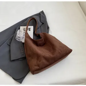 Gedetailleerd overzicht van bruine suède schoudertas, minimalistische vintage tas.