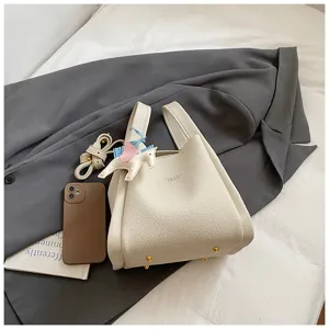 Elegant white bucket bag with cute unicorn pendant and shoulder strap for women.