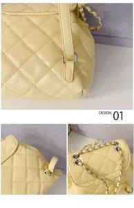 Quilted design detail view of the yellow chain shoulder backpack, showing fine stitching and hardware.