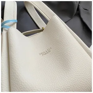 Detailed view of a white textured bucket bag, casual shoulder tote bag with elegant pebble design.