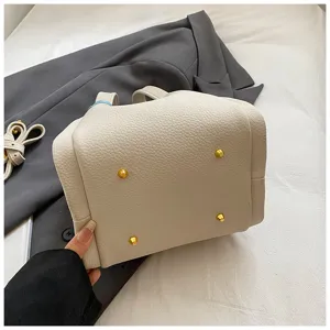 Detailed view of women's PU leather bucket bag bottom with metal feet, stylish daily handbag.
