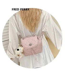 Pink quilted leather backpack detail, featuring metal chain straps and cute dog plush pendant.