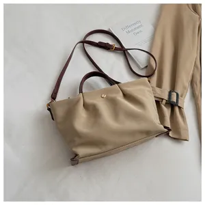 Detailed view of casual nylon crossbody bag with brown leather straps and spacious design.