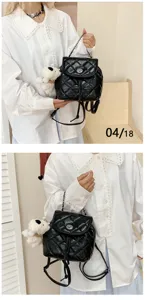 Detailed view of black quilted mini backpack with chain strap and cute bear pendant.