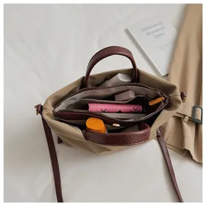 Detail view of khaki nylon crossbody bag interior, showing large capacity compartments.