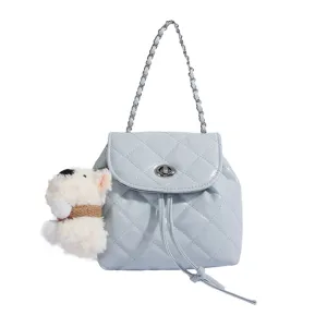 Close-up of light blue quilted mini backpack detail, featuring silver chain strap and lock.