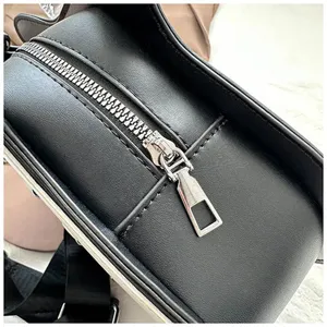 Detailaufnahme der schwarzen PU-Leder-Umhängetasche mit robustem Metallreißverschluss und feinen Nähten.