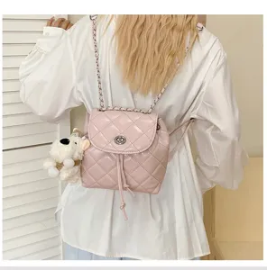 Pink quilted leather backpack with chain straps, twist lock closure, and cute bear pendant.