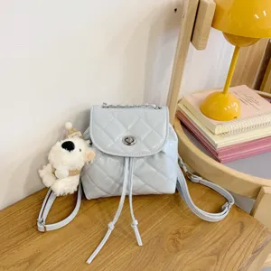 Trendy light blue quilted mini backpack with chain strap and cute plush bear pendant.