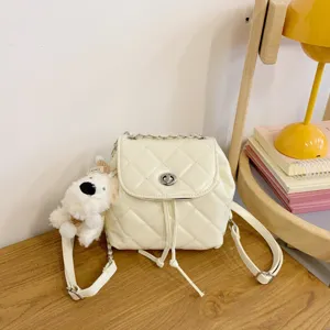Stylish white quilted backpack for women with metal chain strap and cute plush dog pendant.