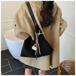 Detail shot of stylish black large capacity shoulder bag with chic charm for women commuting.