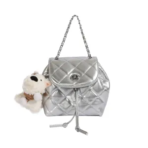 Silver quilted mini backpack with chain strap and cute bear charm, trendy travel shoulder bag.
