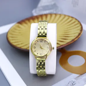 Detailed view of women fashion gold quartz watch with radial pattern dial and metal strap.