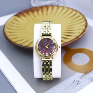 Detail view of the elegant gold quartz watch with a striking maroon radial dial and metal strap.