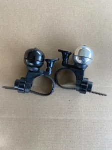 Gros plan détaillé des sonnettes de vélo avec dômes métalliques et sangles de fixation.
