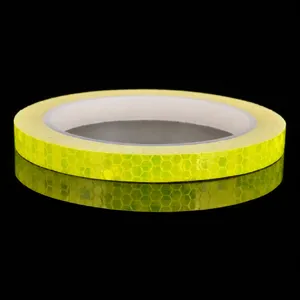 Rotolo di nastro adesivo riflettente giallo con struttura a nido d'ape per la sicurezza.