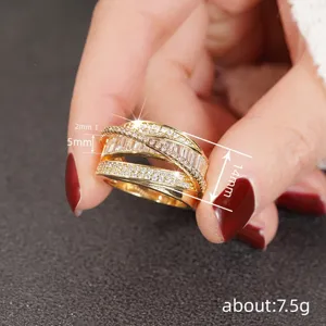 Detailed close-up shot of wide multi-band crossover ring with baguette and pavé stones.