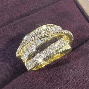 Close-up of a luxury multi-layer cross gold ring sparkling with rhinestones in box.