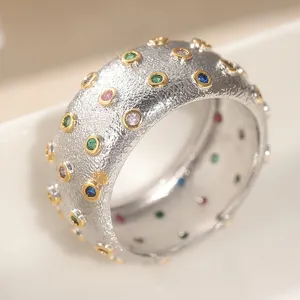 Anello largo e testurizzato con pietre di zircone colorate, elegante gioiello di moda quotidiana.