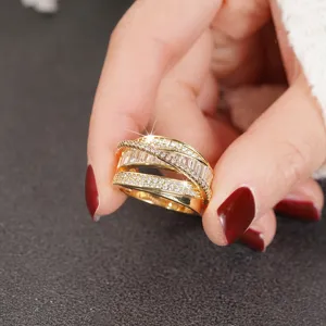 Close-up detail of a stunning gold multi-band crisscross ring with sparkling baguette and pave stones.
