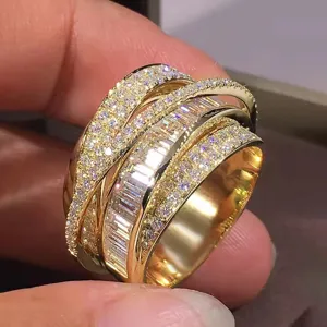 Women's wide multi-band crossover ring featuring sparkling pave diamonds and baguette stones in gold tone.