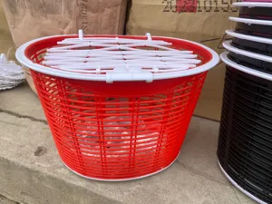 Vue detaillee d'un panier de velo en plastique rouge et blanc avec couvercle grille.
