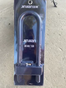Detailed view of the black U-shaped glass door lock in blister packaging showing lock body.