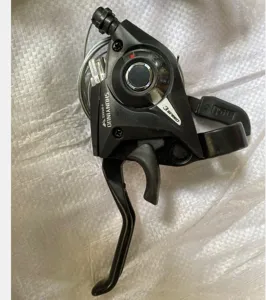 Detailed closeup of black bicycle gear shifter and brake lever with connected shift cable