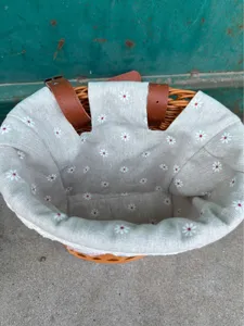 Detailed view of the woven bicycle basket interior, daisy floral fabric liner and straps.