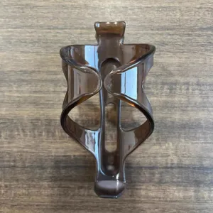 Detailed view of brown translucent plastic bicycle bottle cage, durable cycling accessory.