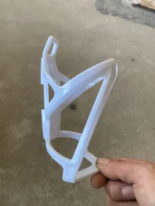 Close-up of white plastic bicycle water bottle cage, durable cycling accessory detail view.