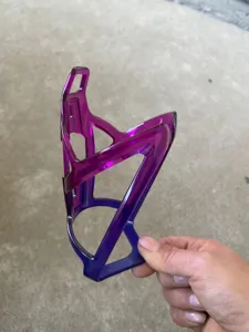 Detail view of a colorful plastic bicycle water bottle cage showing its gradient design.