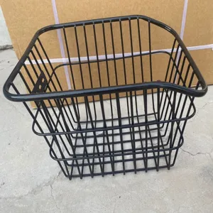 Dettaglio del cestino posteriore per bici in metallo nero, design a rete metallica.