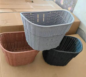 Detail shot of woven plastic bicycle front baskets in multiple colors showing mesh design and slots.