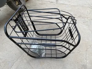 Vista detallada de la cesta delantera de bicicleta de metal negro resistente con tapa.