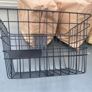 Detail view of the black metal bicycle basket front mounting bracket and sturdy wire mesh structure.