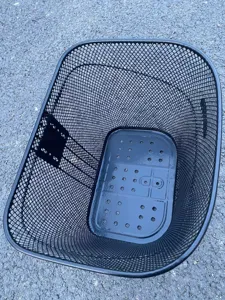 Detailed view of black metal wire bicycle front basket with sturdy bottom plate mesh design.