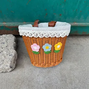 Woven bicycle basket with lace lining and cute crochet flowers for front handlebar storage.